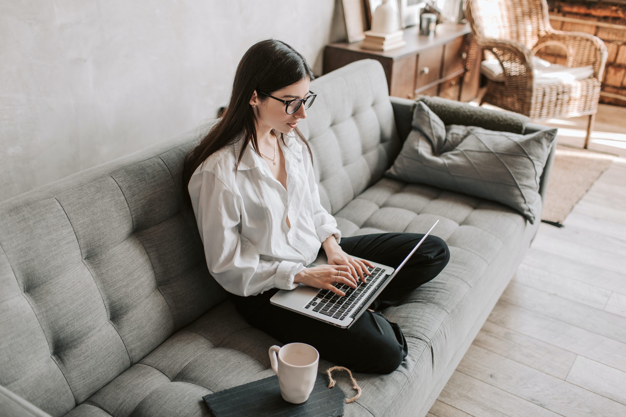 A lady working on laptop sitting on a sofa